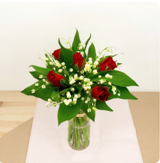 Ce charmant bouquet est composé de muguet en brin et de roses rouges.